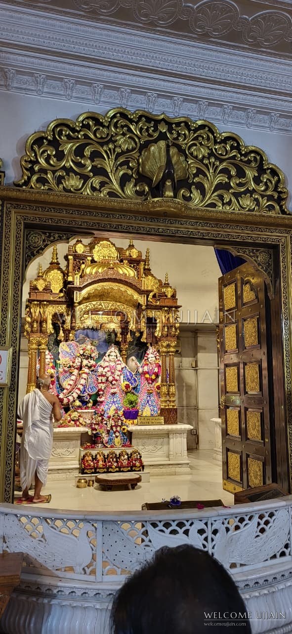 ISKCON Sri Sri Radha Madan Mohan Mandir — The gold altar of Sri Sri Radha Madan Mohan, with a priest at the deities